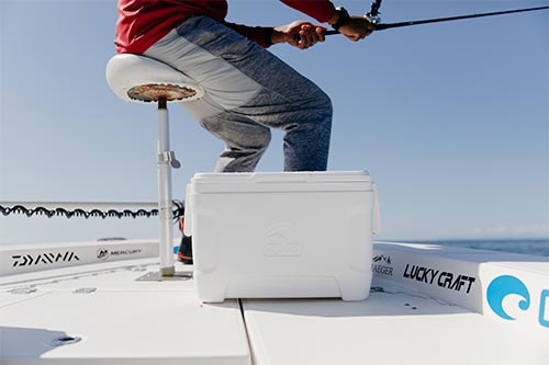 Hobre pescando en barco con nevera blanca Marine 25